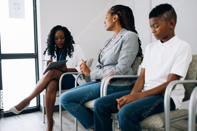 Black doctor consulting mother and son patients