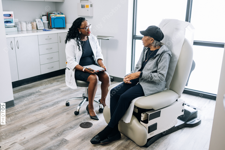 Black female doctor consulting senior patient