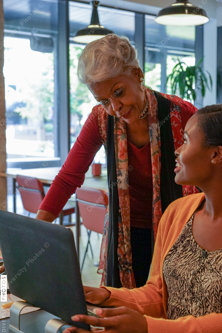 Two women using laptop in office