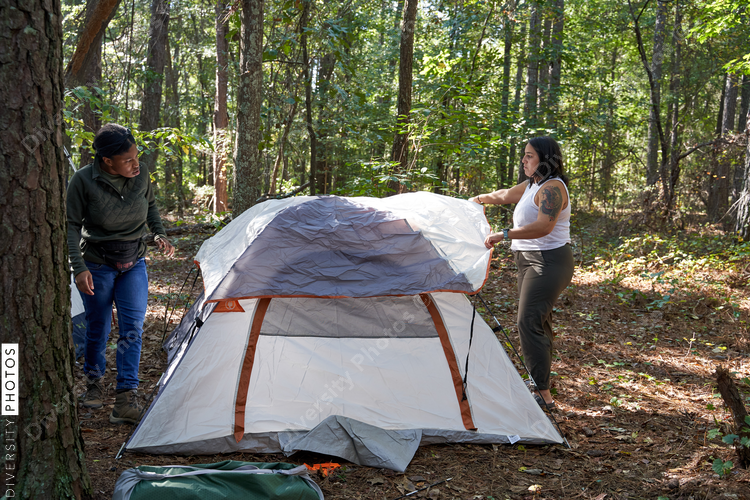 Friends setting up tent at campsite