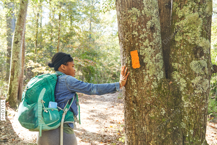 Black woman hiking trail in the woods