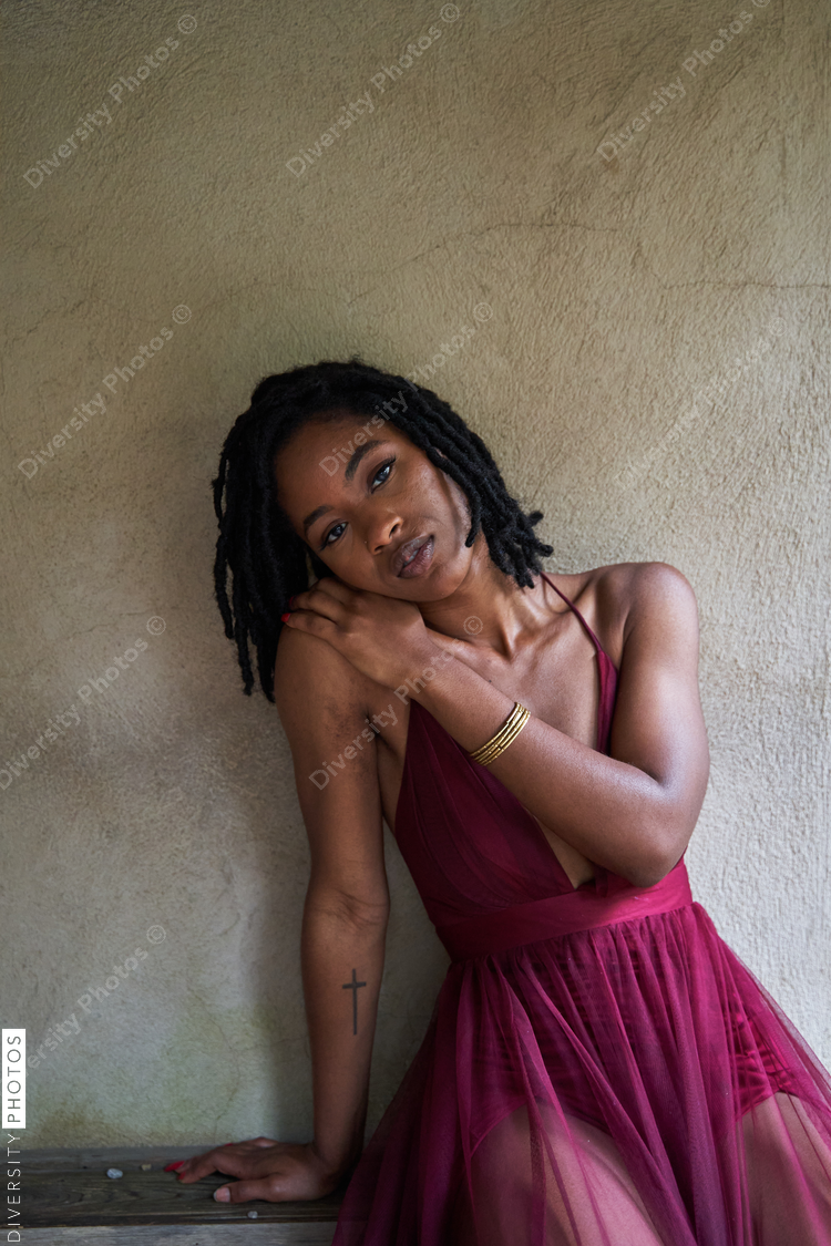 Portrait of pretty Black woman against brown wall, mid adult