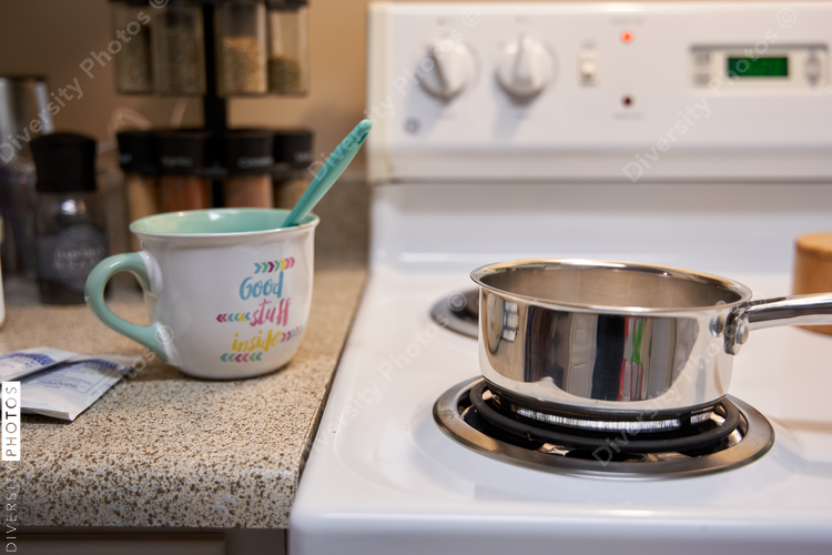Middle class family home kitchen stovetop, pot and coffee mug for hot chocolate