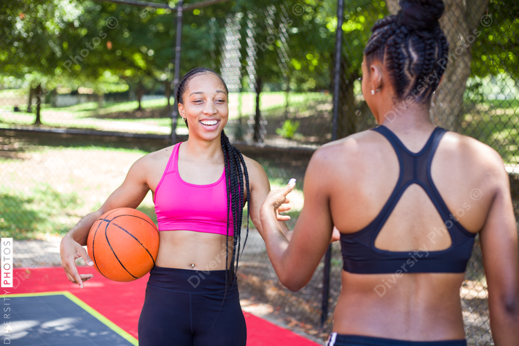 Happy women smiling on basketball court