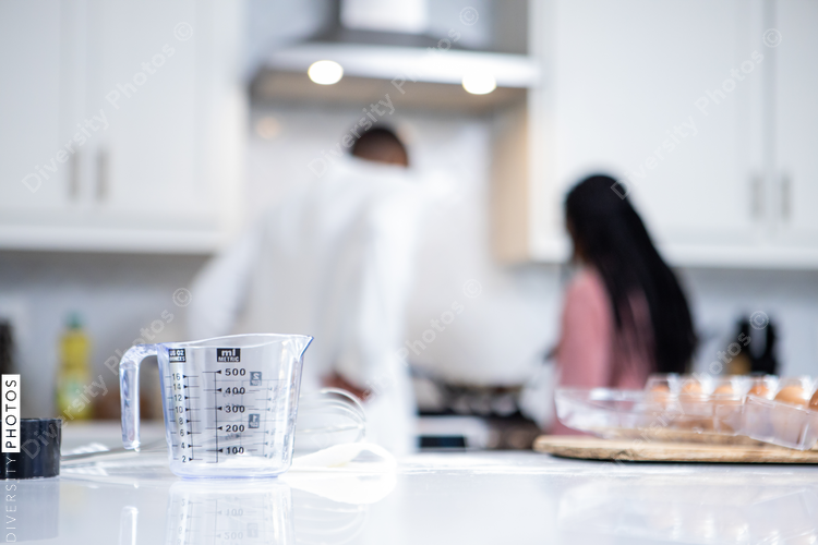 African American father and daughter cooks in kitchen