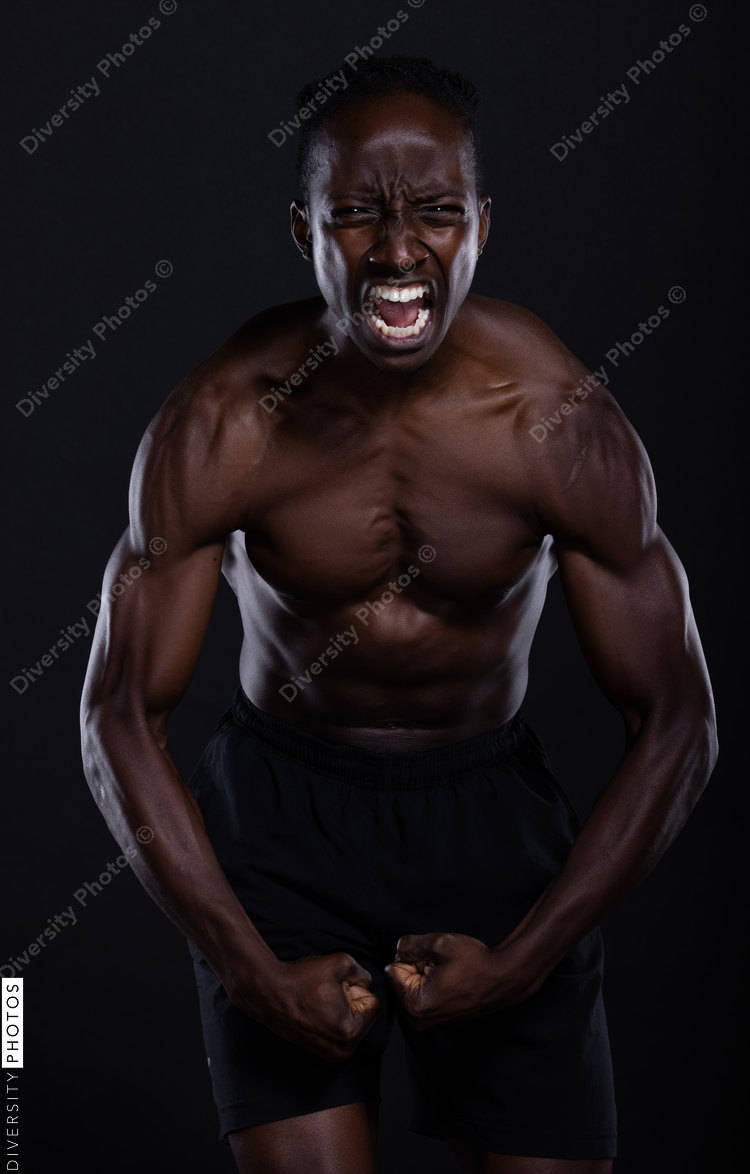 Fit African American man with muscles posing in studio