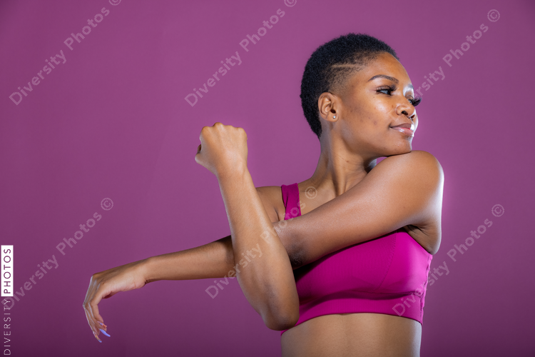 African American woman stretches her arms before workout exercise