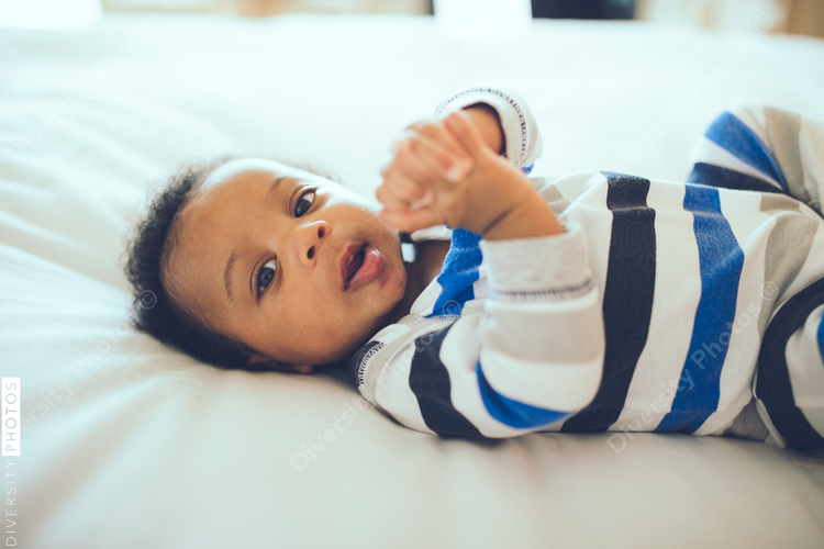 Portrait of baby boy lying on bed at home