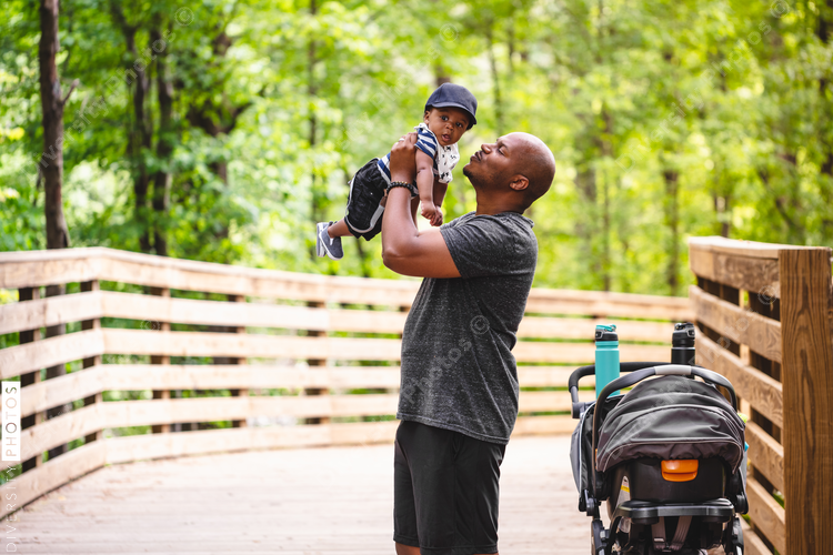 Father holds up baby son for a kiss
