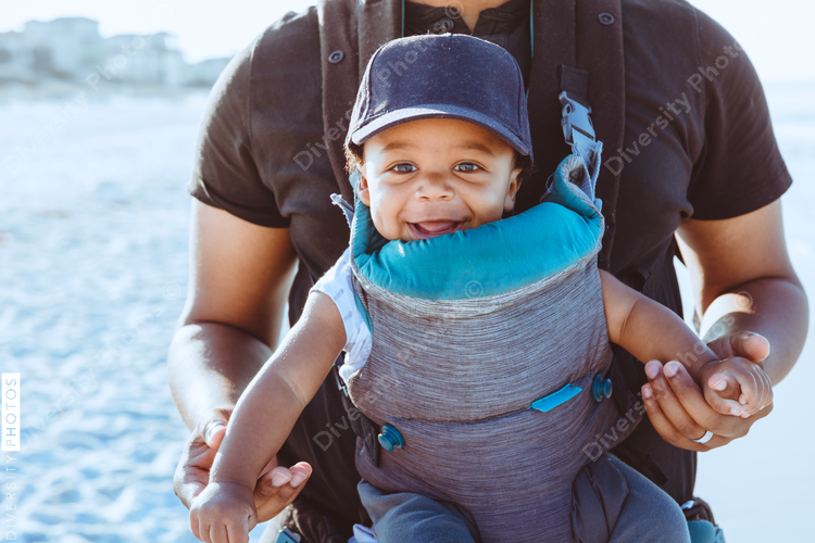 Black father and son walking on the beach