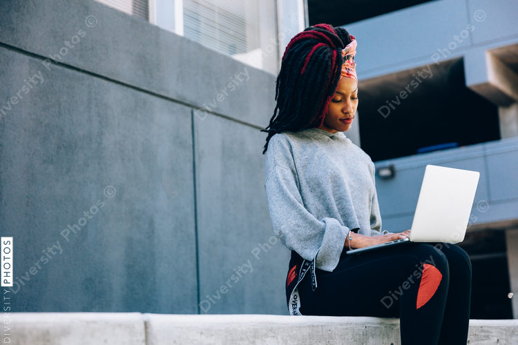 Woman working on laptop outdoors