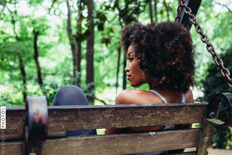 Rear view of woman on park bench swing