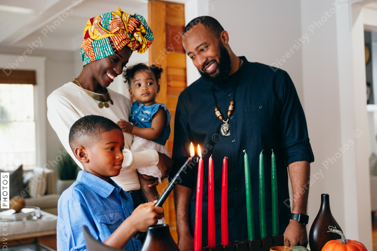 Boy lights candle to celebrate Kwanzaa