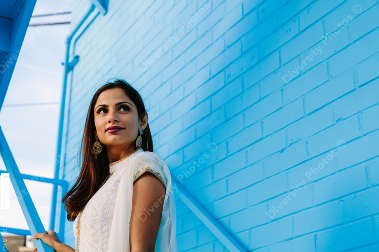 Portrait of woman standing on steps against wall