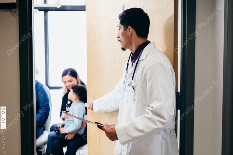 Latino doctor entering exam room to meet with patients