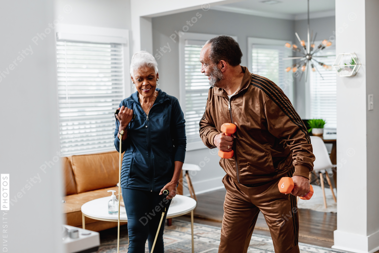 African American senior couple exercises together at home