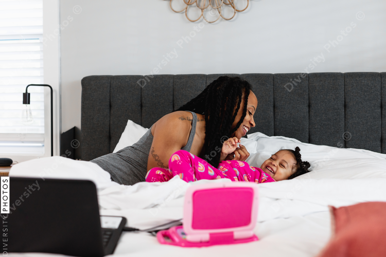 Mother and daughter laughing, tickle, and having fun at home