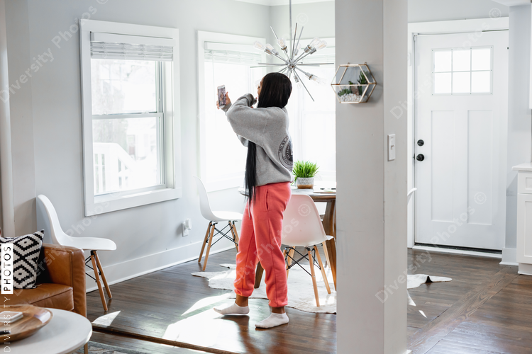 Black teen girl on social media at home
