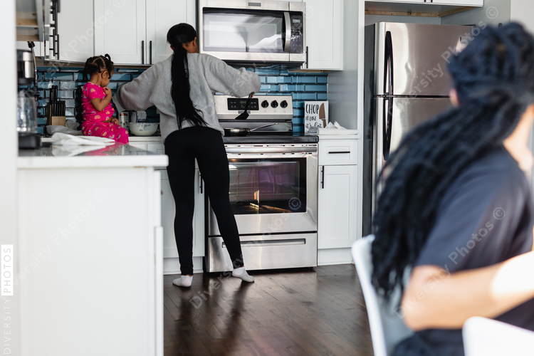 Black family preparing breakfast in kitchen