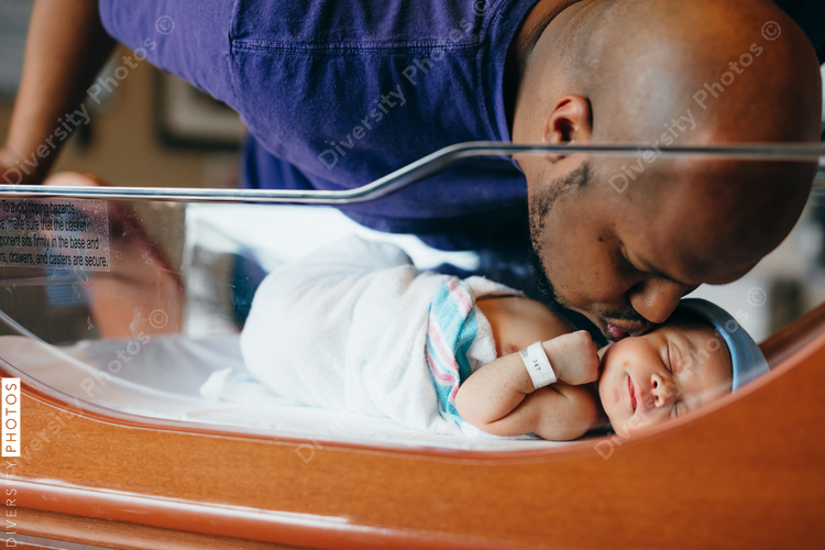 Black dad kisses newborn at hospital