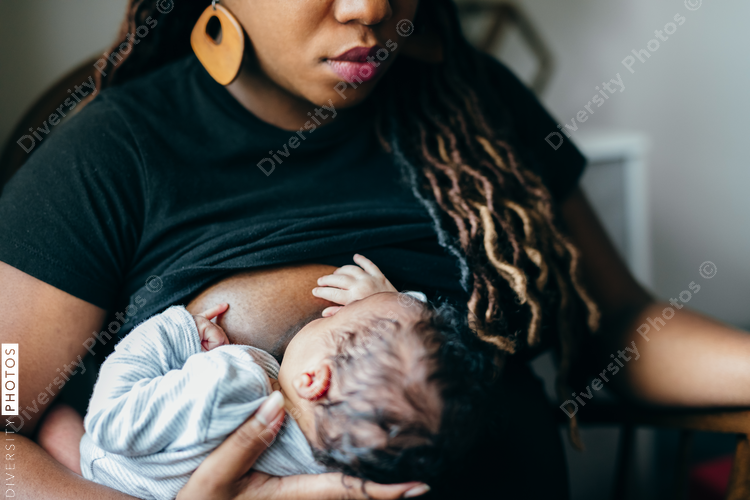 Black woman breastfeeding child at home