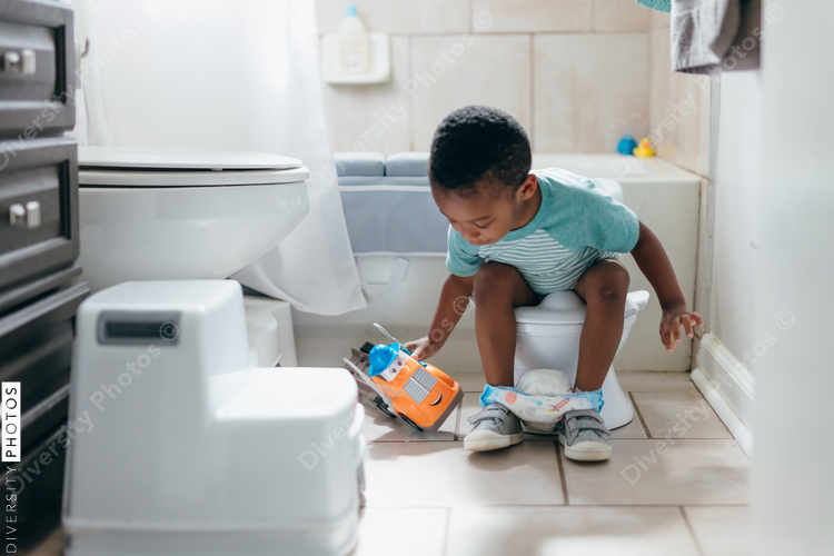 Black boy, potty training time at home, playing with toy truck