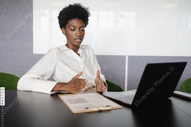 Business woman using laptop and gesturing