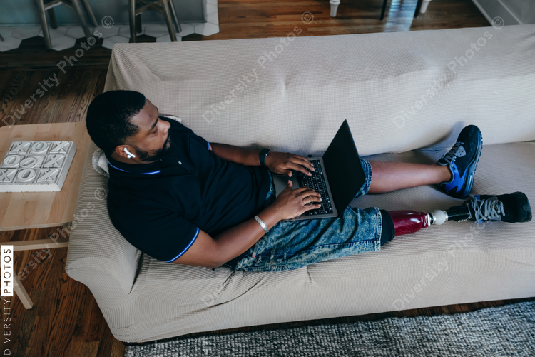 African American man working from home on laptop, disability