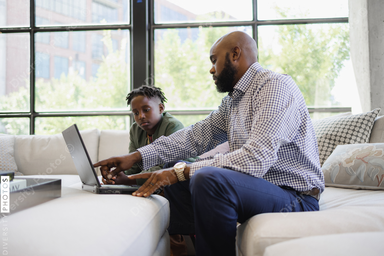 African American Father and son using laptop together