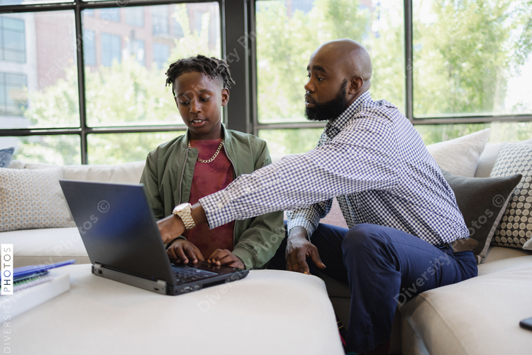 Black dad helps son do homework