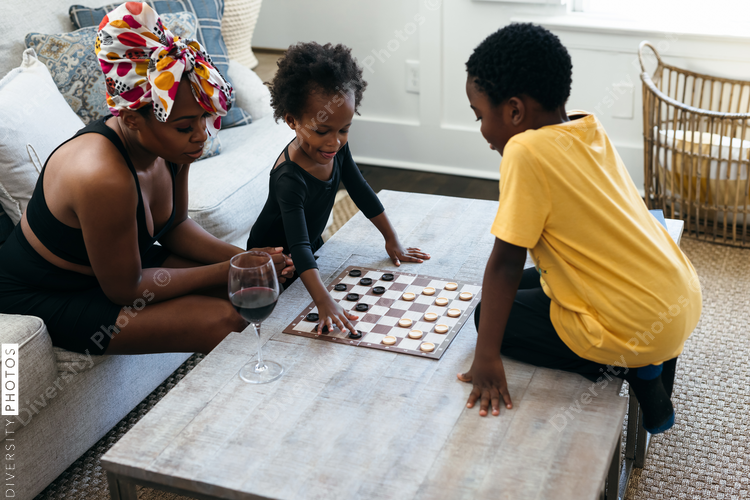 African American family playing checkers game at home