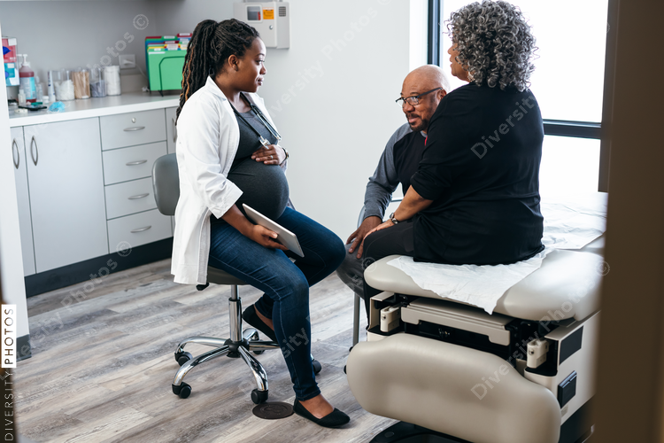 African American female doctor consults with senior medical patients