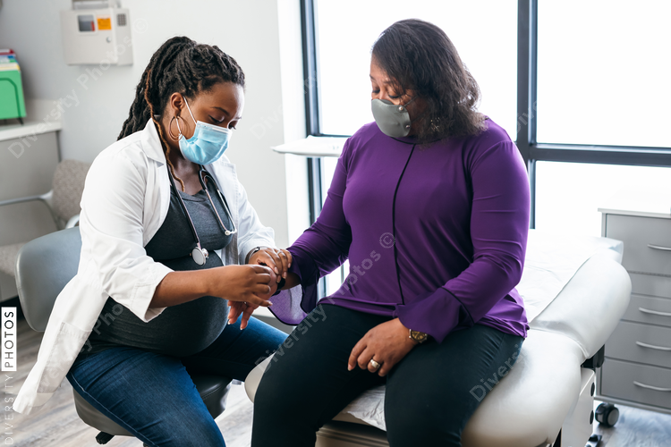 Black doctor consulting with senior patient