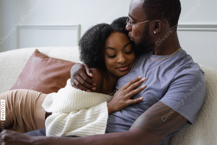 Black Couple hugging on sofa, comfortable