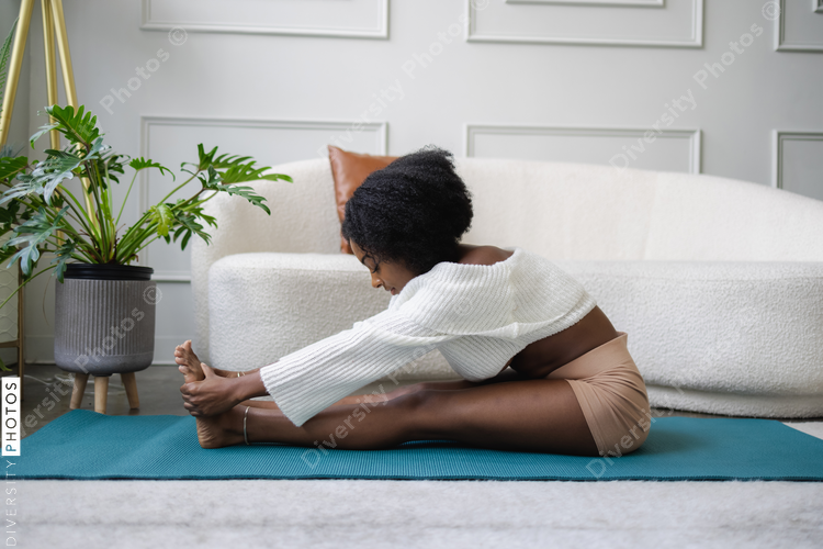 Young woman stretching in living room
