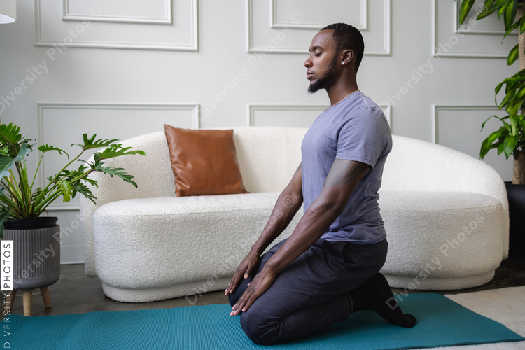 Young man meditating in living room