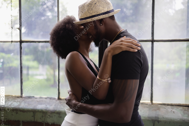 Young couple standing by window and embracing