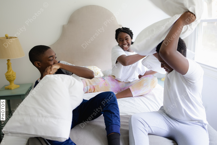 Black siblings having a fun, pillow fight, friendship