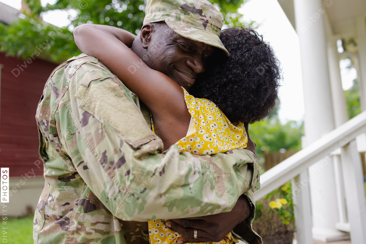 Black military man embraces wife as he is welcomed home