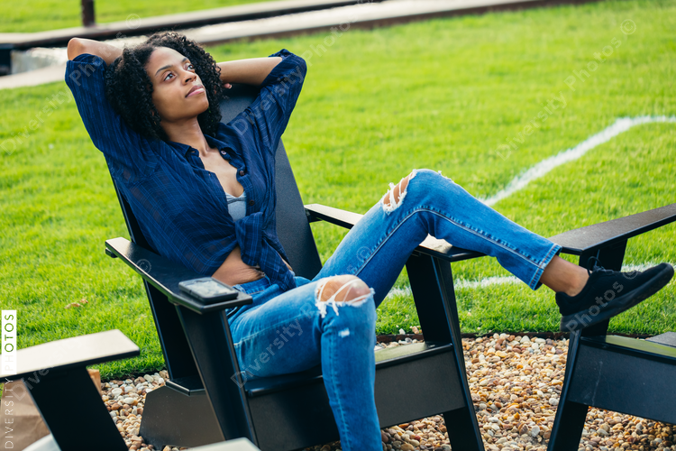 Black woman relaxing in chair near fire pit