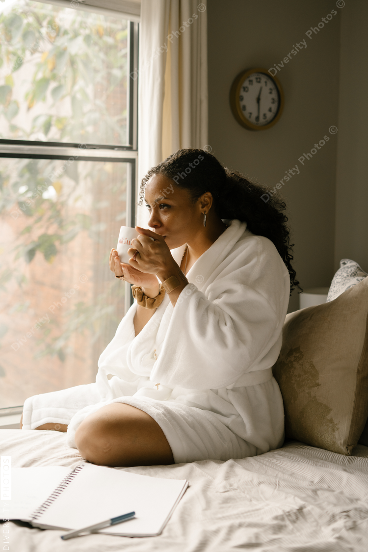 Woman drinking coffee at home in bed