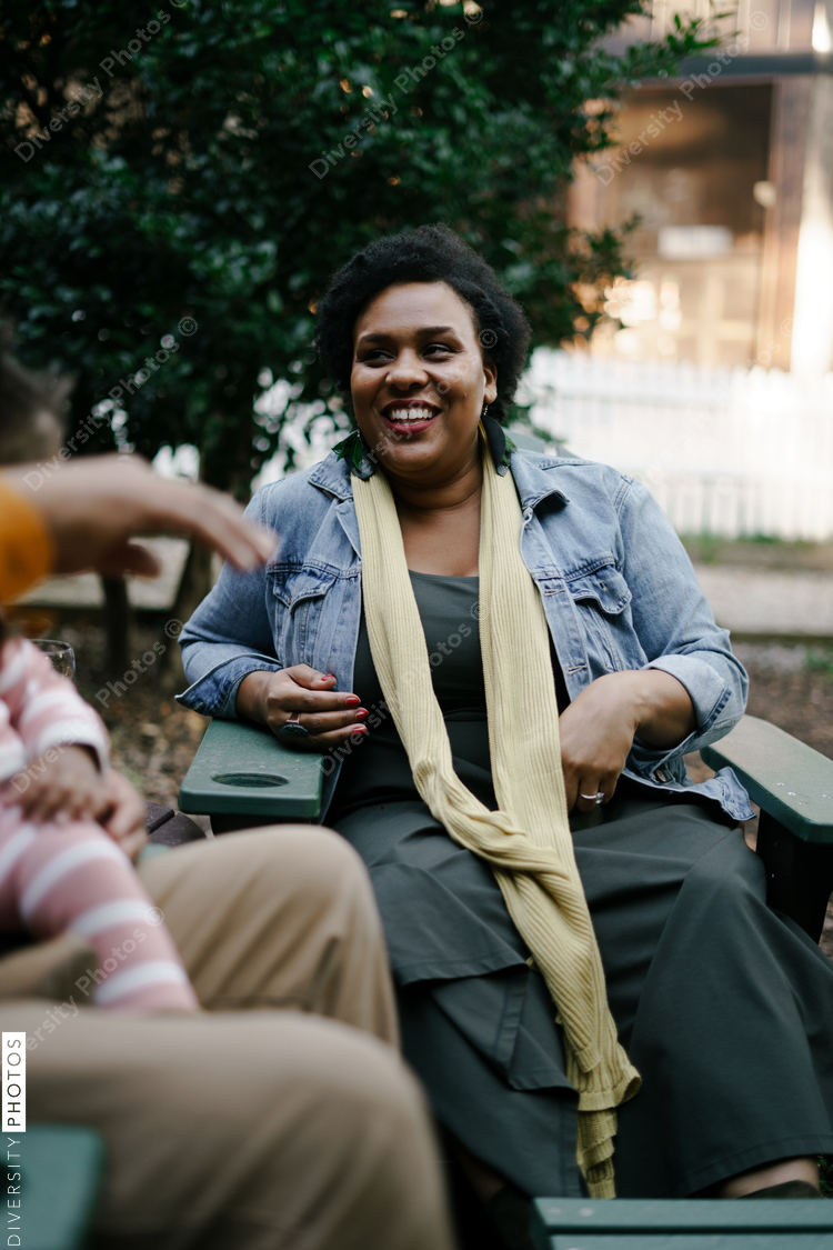 Friends together distanced at backyard party around firepit