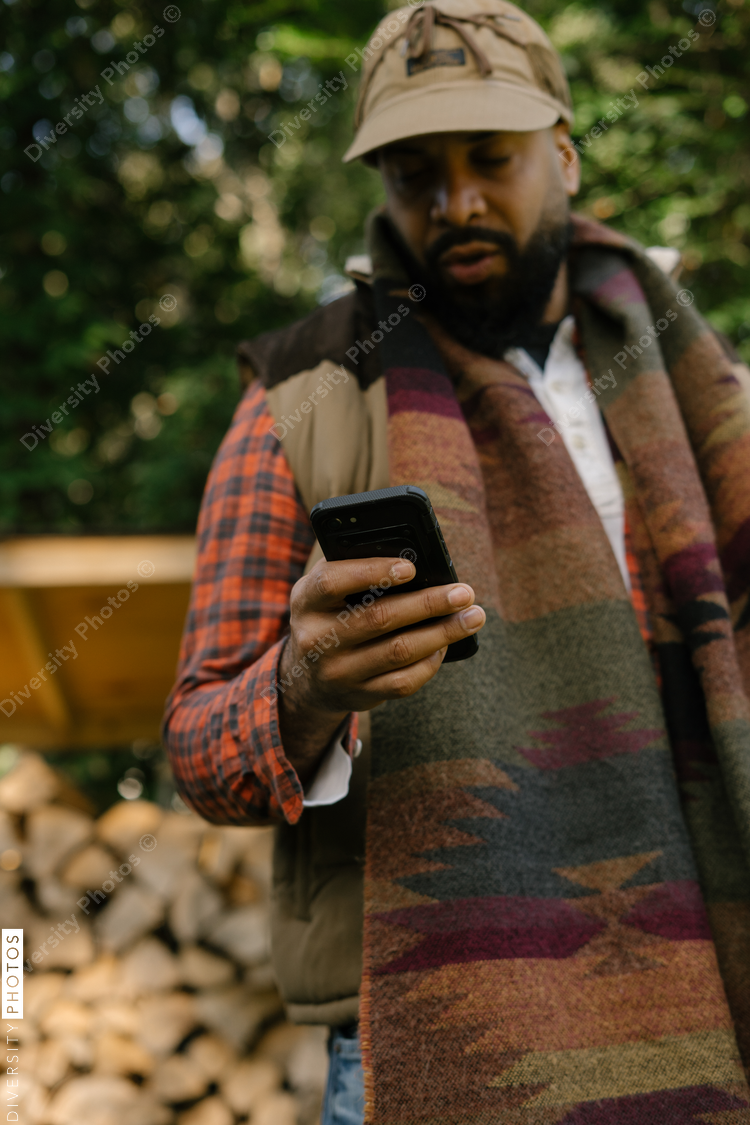 Man checking smartphone in backyard in fall