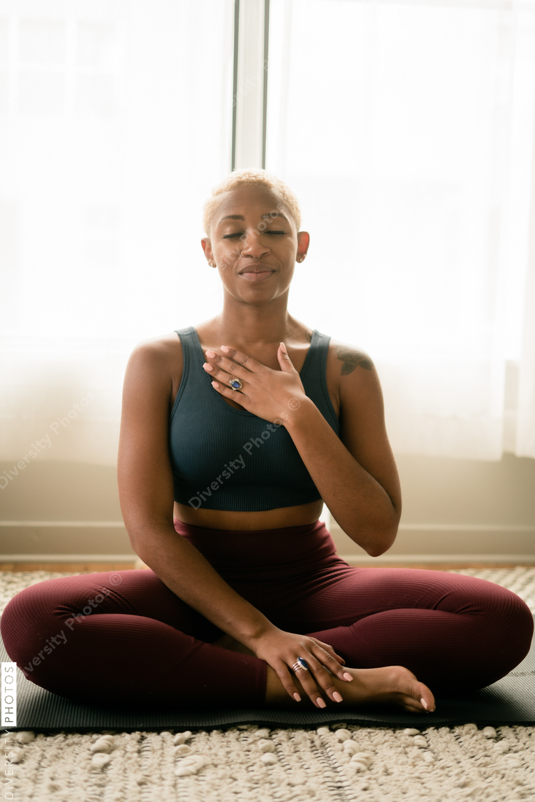 Black woman breathing and doing meditation at home