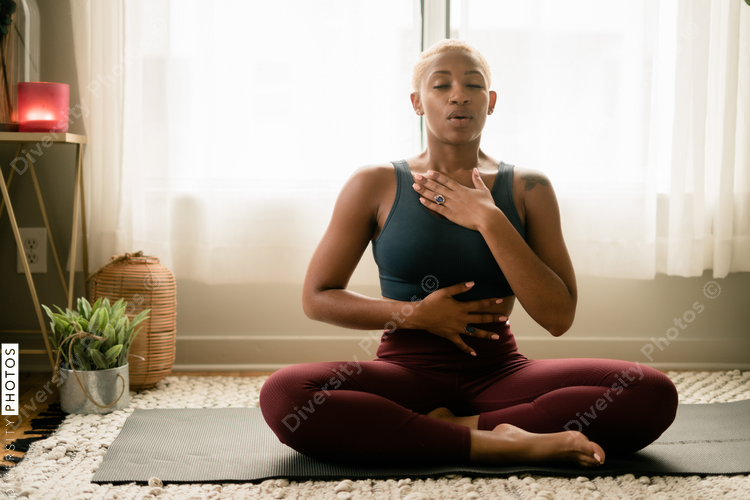 Black woman breathing and doing meditation at home