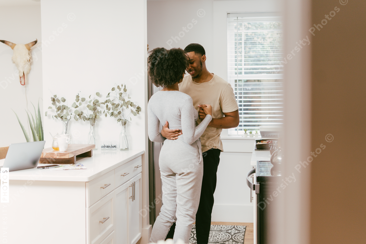 Black couple dancing in kitchen at home, intimate moment