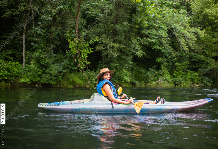 Portrait of smiling woman in kayak on calm on river