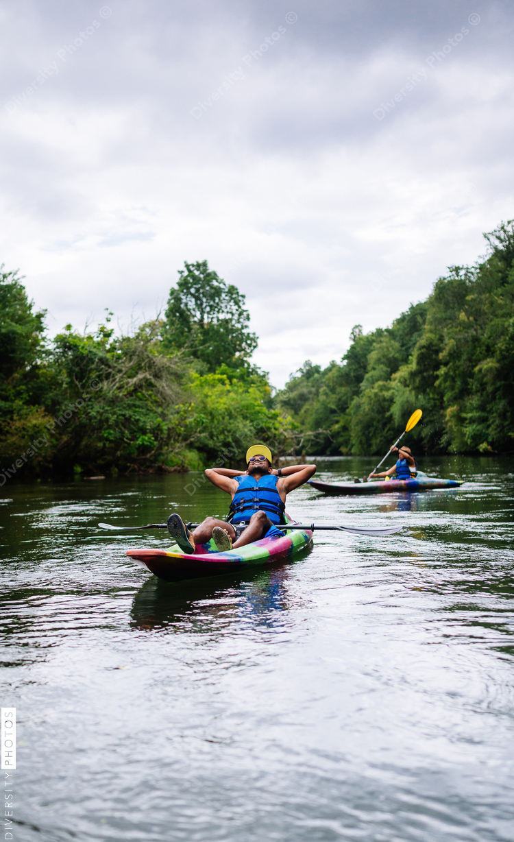 Relaxed man kayaking on calm river