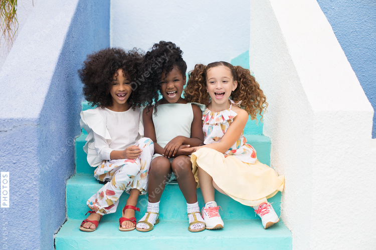 Three girls sitting on steps and laughing