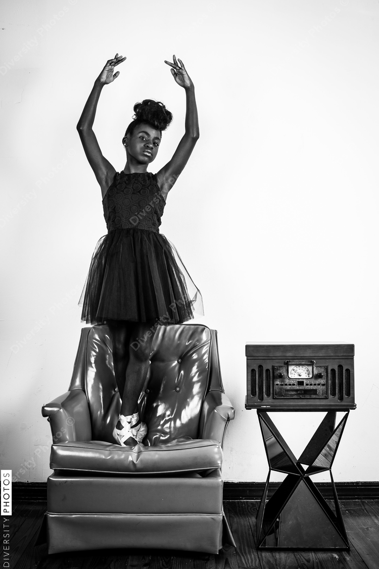 Girl performing ballerina pose on the chair